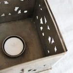 Metalinės dėžutės - žvakidės viduje yra vieta arbatinei žvakutei
