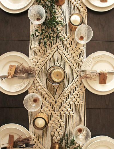 Padekoruotas stalas su žvakidėmis ir stalo takeliu šventiniam stalui